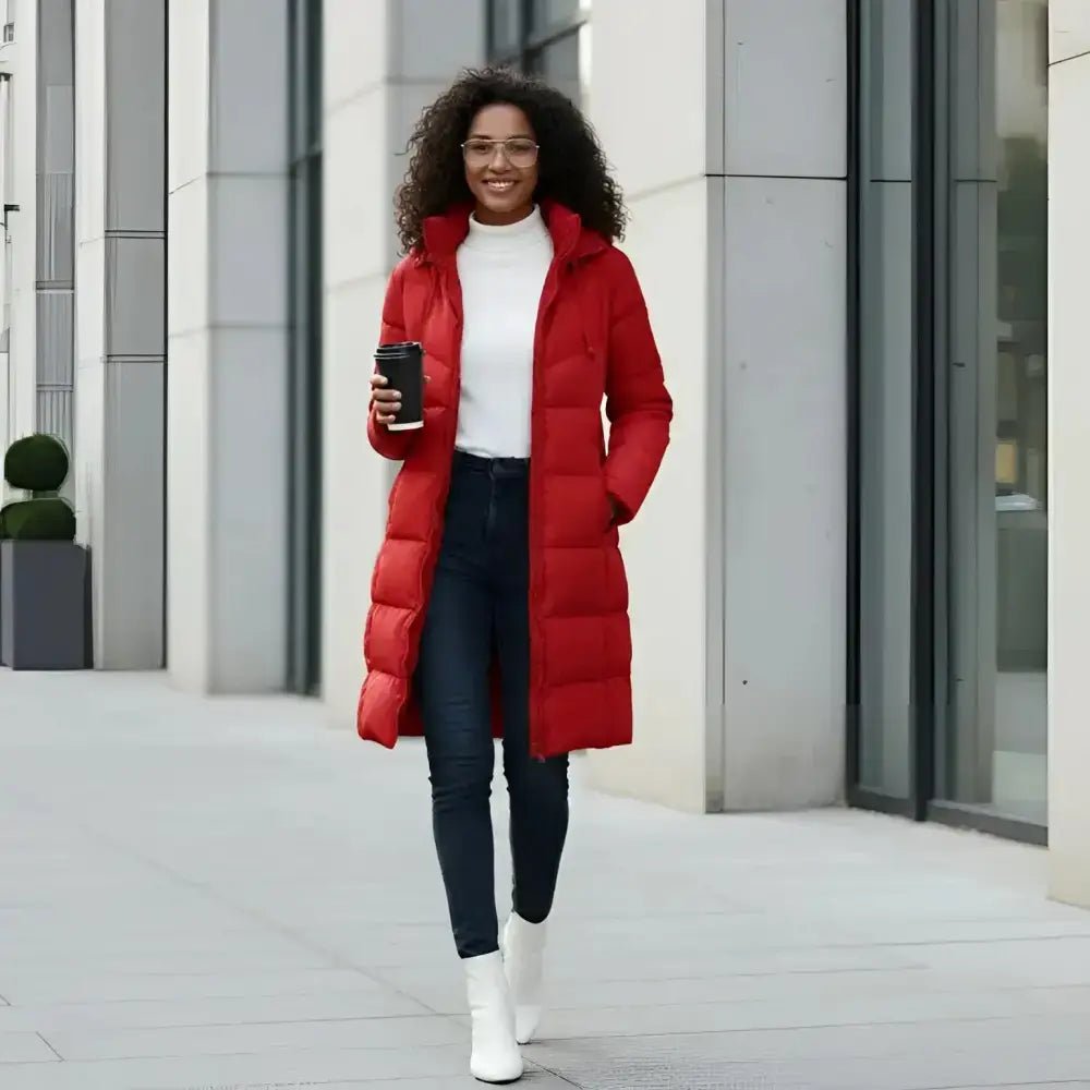 Femme souriante portant une parka femme longue imperméable chaude rouge avec un gobelet à emporter.