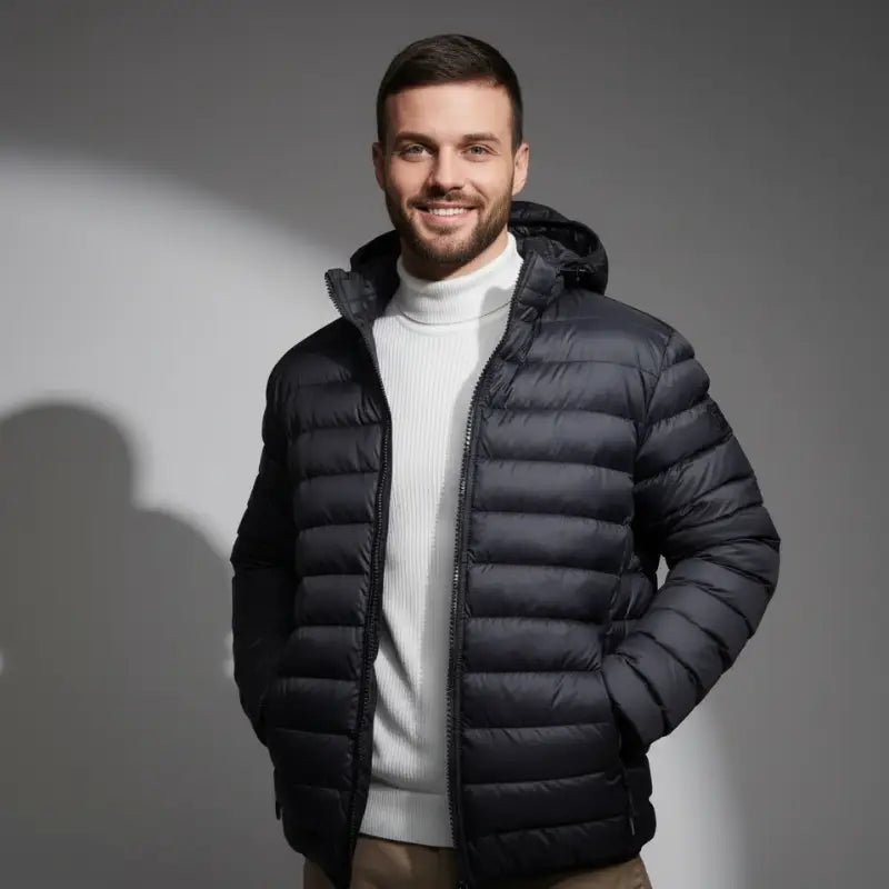 Parka doudoune homme légère à capuche coloris noir portée par un homme souriant.