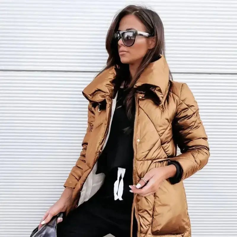 Parka femme longue en matériau matelassé couleur bronze, idéale pour l'hiver, avec col montant et style élégant.