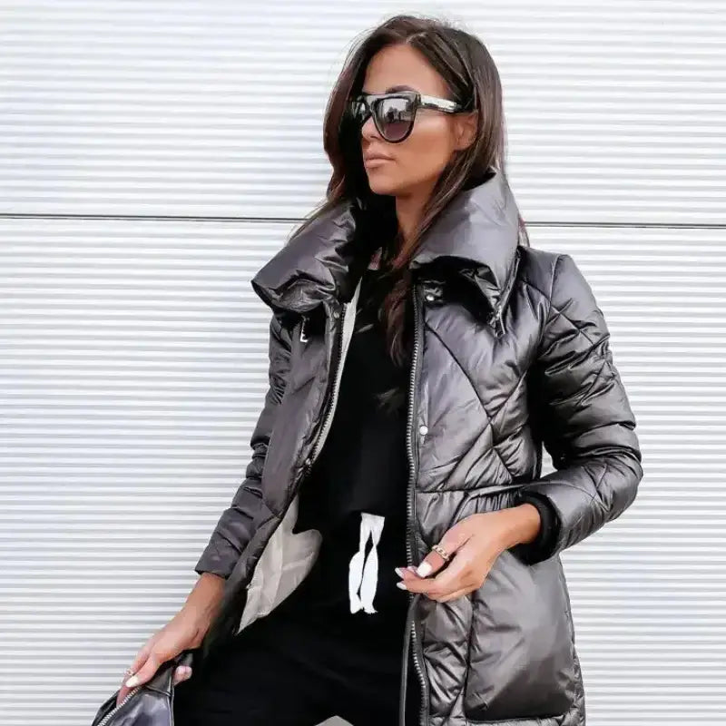 Parka femme matelassée brillante portée par une femme avec des lunettes de soleil, montrant son style moderne.
