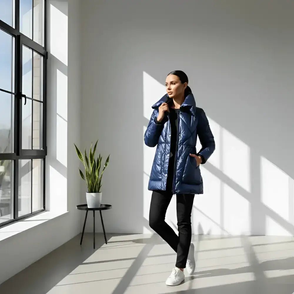 Parka femme matelassée brillante bleu portée par une femme, style moderne dans une pièce lumineuse.