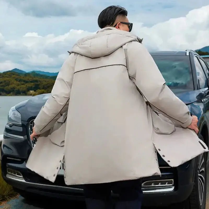 Parka longue homme en couleur beige, vue arrière, portée par un homme près d'une voiture.