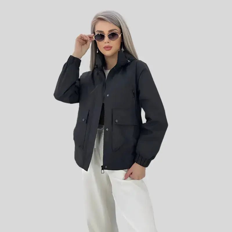 Parka noire femme légère portée par un modèle avec lunettes de soleil, style décontracté et moderne.